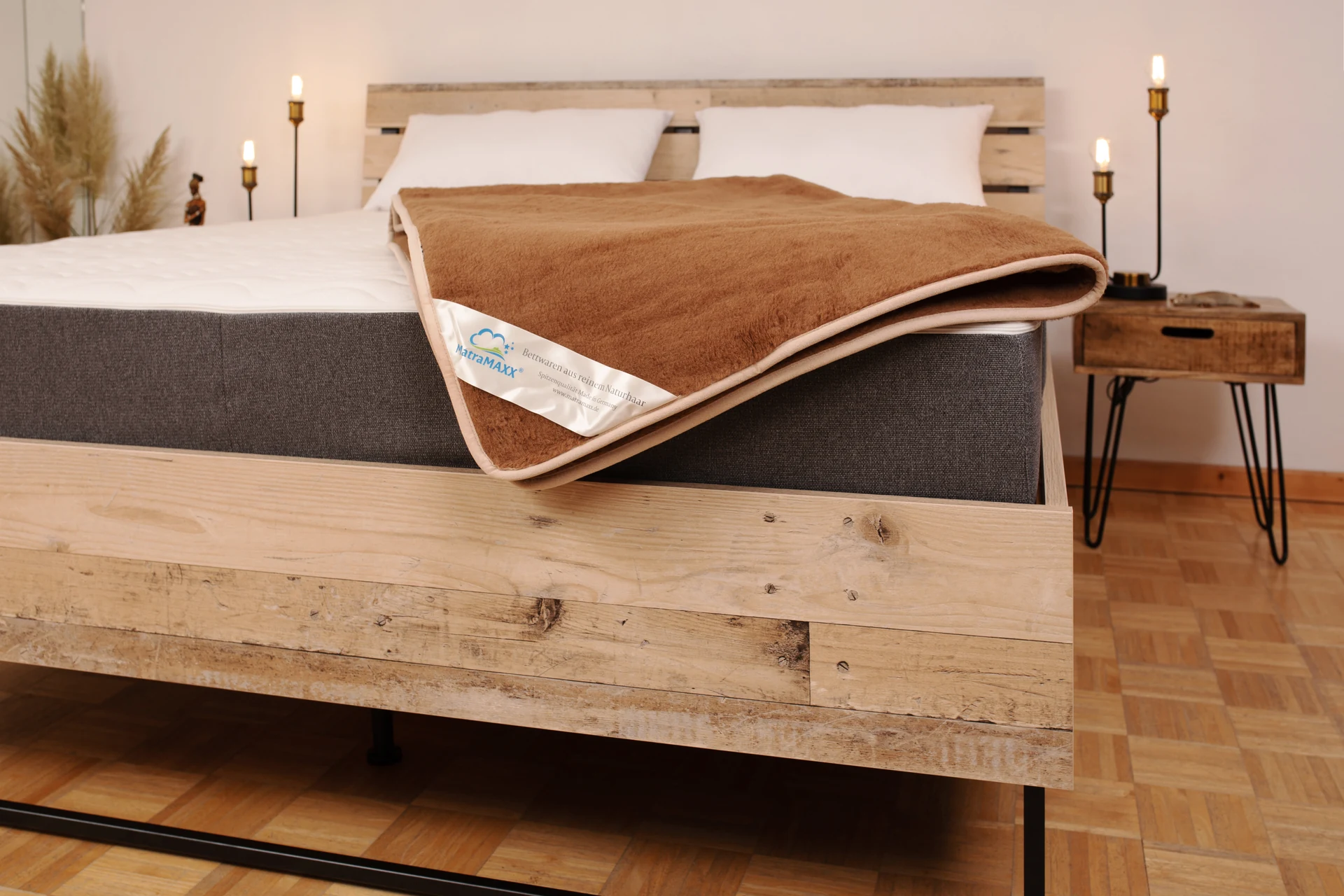 Kamelhaar-Flordecke auf einem Bett — offener Flor, warme Farbtöne